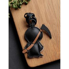 a wooden cutting board topped with an ironing board and a black leather keychain