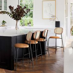 a kitchen island with four stools next to it