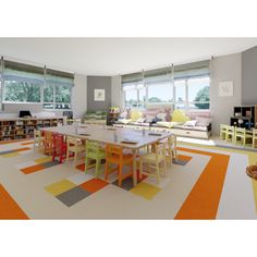 a room with tables, chairs and bookshelves filled with lots of books in it