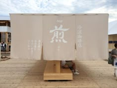 two people sitting on benches in front of a building with chinese characters painted on it