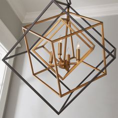 a chandelier hanging from the ceiling in a room with white walls and windows