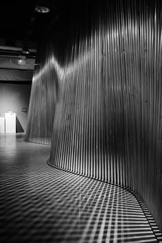 a black and white photo of an empty room with lines on the wall behind it