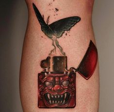 a tattoo with an image of a bird on top of a box and a knife sticking out of it