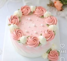 a pink and white cake with flowers on it