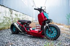 a red scooter parked next to a building