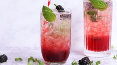 two tall glasses filled with different types of drinks and garnished with mint leaves