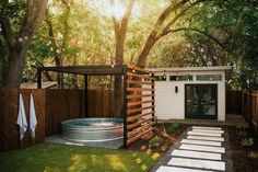 a small backyard with a hot tub and wooden fenced in area next to trees