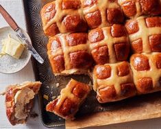 hot cross buns on a cutting board with butter