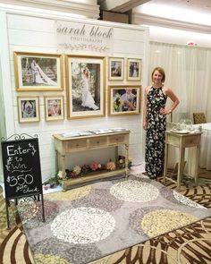 a woman standing in front of a table with pictures on it