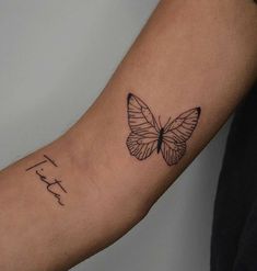 a small butterfly tattoo on the left arm and right arm, with writing below it