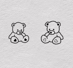 two teddy bears sitting next to each other on a white paper background with black ink