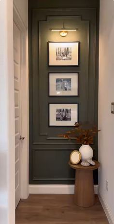 a hallway with pictures on the wall and a potted plant