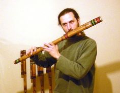 a man holding a wooden flute in his hands