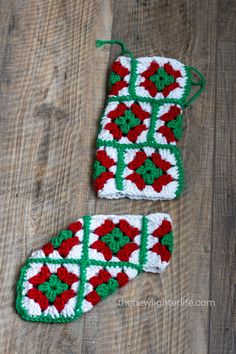 two crocheted christmas stockings sitting on top of a wooden floor next to each other