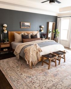 a bedroom with a large bed and two stools