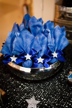 a bowl filled with blue flowers on top of a table