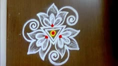 a painting on the side of a wooden door with white and red designs painted on it