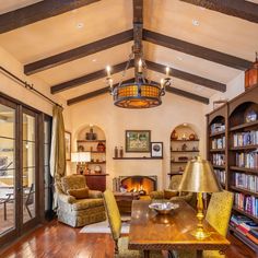 a living room filled with furniture and a fire place next to a book shelf full of books