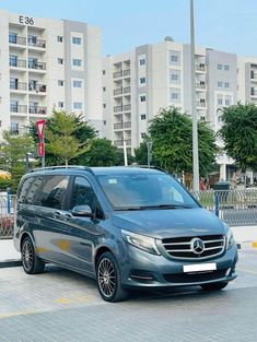 a grey van is parked in front of some buildings