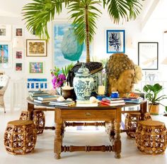 a living room filled with lots of furniture and plants on top of a wooden table