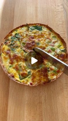 a pizza sitting on top of a wooden cutting board with a knife stuck in it