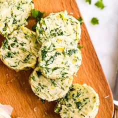 some food is sitting on a cutting board next to garlic and parmesan cheese