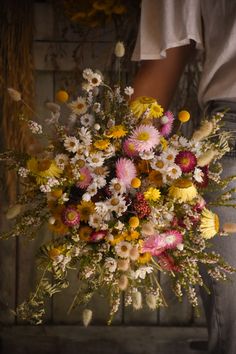 a person holding a bouquet of flowers in their hands