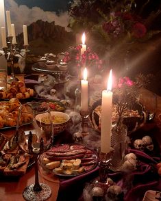 a table topped with lots of food and candles