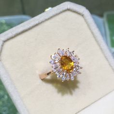 an orange and white diamond ring in a box