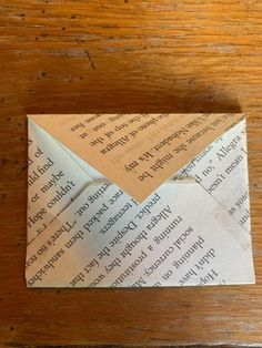 an origami envelope on a wooden table with the letter written in black ink