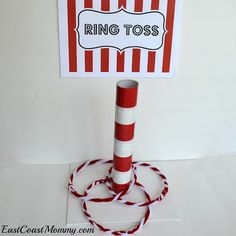 a red and white striped sign on top of a pole with a rope around it