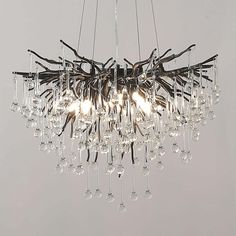 a chandelier made out of branches and wine glasses hanging from it's center