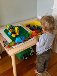 a toddler playing with toys on a table in the living room or playroom