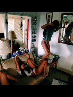 two young women hanging upside down in a living room