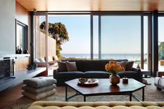 a living room filled with furniture and large windows