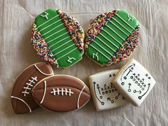 decorated cookies with football, football field and stars on them are sitting on a sheet of paper