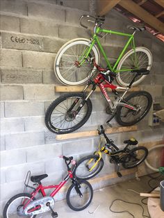 two bikes are hanging on the wall and one is upside down, while the other stands up