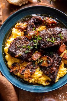 a blue plate topped with meat and grits