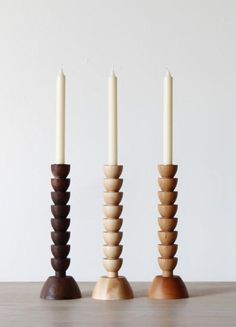 three wooden candles are lined up on top of each other with one candle in the middle