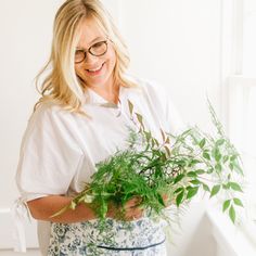 a woman holding a potted plant in her hands