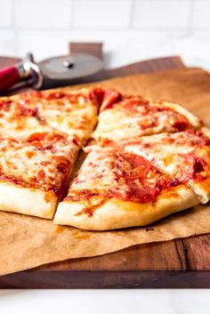 a pizza sitting on top of a wooden cutting board