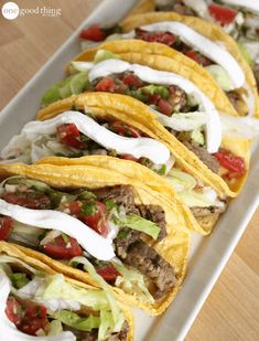 some tacos are lined up on a white plate