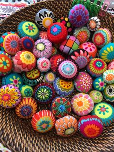 a basket filled with lots of colorfully painted rocks