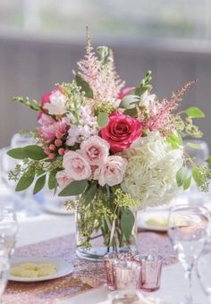 a vase filled with pink and white flowers on top of a table