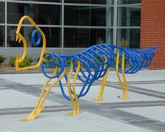 several blue and yellow sculptures in front of a building