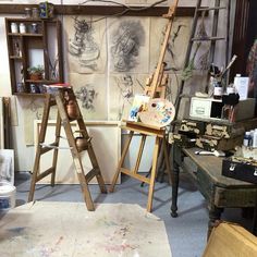 an artist's studio with easels and paintings