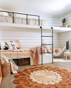 a bedroom with bunk beds and hammocks on the wall, rugs in front of them