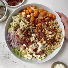 a white bowl filled with lots of food on top of a table