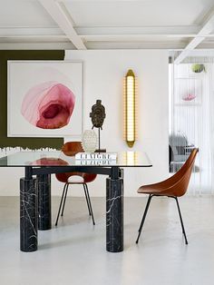 a modern dining room with marble table and chairs