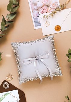 a white ring pillow sitting on top of a table next to some cards and flowers